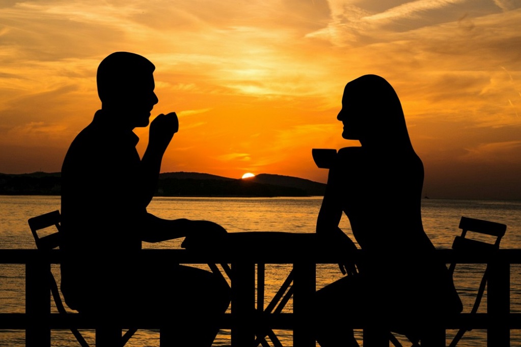 couple watching sunset drinking coffee